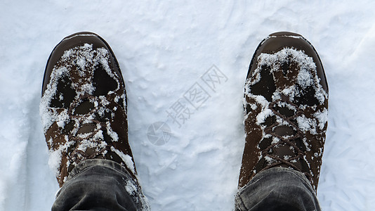 穿着白雪皑皑的冬靴的男性腿部 顶视图 冬天在雪地里散步 专注于你的腿 美丽的白色冬季天气与新鲜的降雪图片