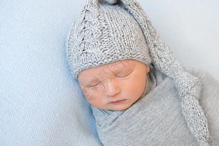 可爱的婴儿 穿着毛绒灰帽睡午睡灰色童年织物材料羊毛衣服男生孩子新生帽子图片