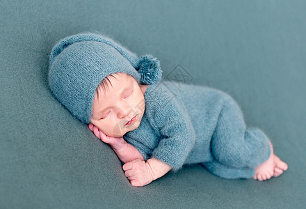 婴儿婴儿男孩睡在羊毛衣服上 赤脚裸露身体冒充睡眠童年帽子孩子卫生儿子保健微笑图片