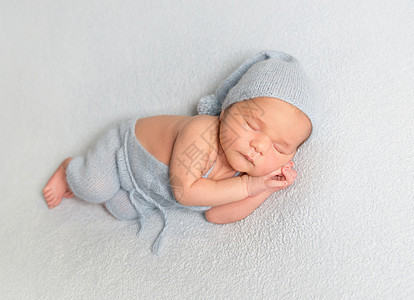 婴儿男孩卷在白毯子上针织地毯男生帽子女孩孩子时间睡眠皮肤身体图片