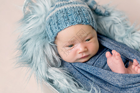 新生婴儿带着蓝色毯子躺在沟里襁褓说谎篮子微笑帽子小憩童年男生内裤孩子图片