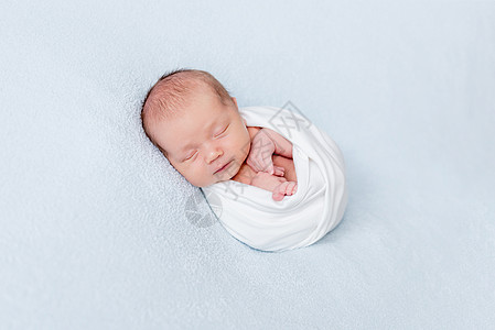 新生婴儿睡在毯子中图片
