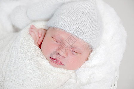 白包装的新生儿躺在篮子上圆形梦幻女孩白色午睡新生童年孩子婴儿小憩图片