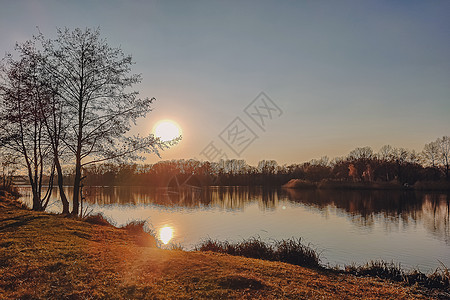 生动的秋天日落 日落秋天风景在河的与光亮的草在岸上 明亮的夜晚风景秀丽 天空五彩缤纷晴天场景蓝色季节日出森林反射阳光地平线公园图片