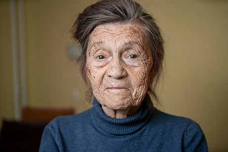 90 岁的可爱老妇人 头发花白 脸上有皱纹 穿着毛衣 肖像很大 微笑着 看起来很快乐 房间的背景 主题长肝抗衰 老人心情好奶奶老图片