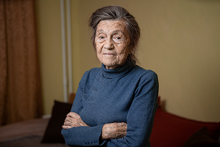 90 岁的可爱老妇人 头发花白 脸上有皱纹 穿着毛衣 肖像很大 微笑着 看起来很快乐 房间的背景 主题长肝抗衰 老人心情好退休祖图片