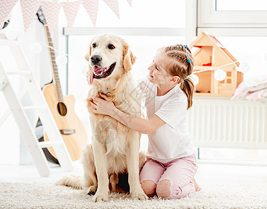 快乐的小女孩抱着美丽的狗孩子游戏室乐趣玩具宠物微笑公寓动物女性小学生图片