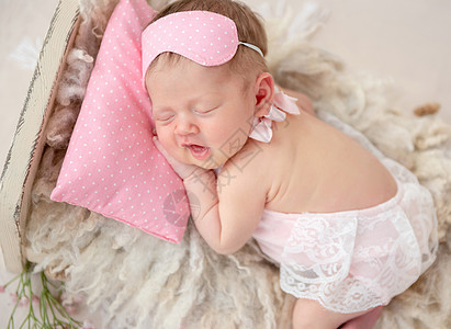 新生儿睡在很小的床上毯子休息孩子女孩拖鞋枕头冒充柔软度幸福童年图片