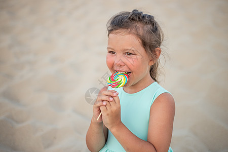 有大五颜六色的棒棒糖的逗人喜爱的小女孩 吃甜棒棒糖的孩子 适合年幼孩子的糖果 夏季户外乐趣幼儿园女孩喜悦微笑公园食物婴儿背景图片