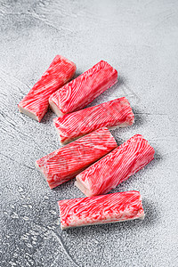 厨房餐桌上的螃蟹缩胶棒 白色背景 顶层视图饮食蟹肉营养美食手指红色海鲜午餐模仿食物图片