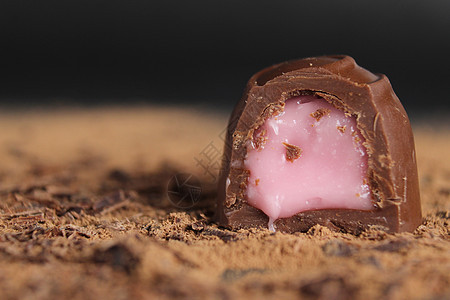 Chocolate带馅料的巧克力糖放在灰黑色背景的可可上 有一个地方可以发短信给甜巧克力棕色背景的副本糖果甜食蛋糕食物海绵诱惑小图片