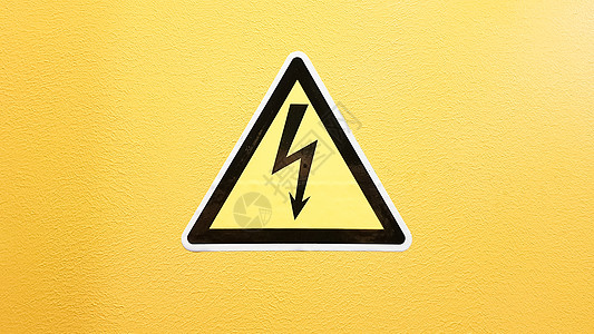 安全标志黄色和黑色粘在黄色的墙上 在三角小心的高压闪电小心危险电死亡注意力震惊冒险标签力量电压金属活力风险贴纸图片