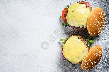 两份自制牛肉汉堡 带奶酪 绿色 洋葱 白色背景 顶视图 复制空间图片