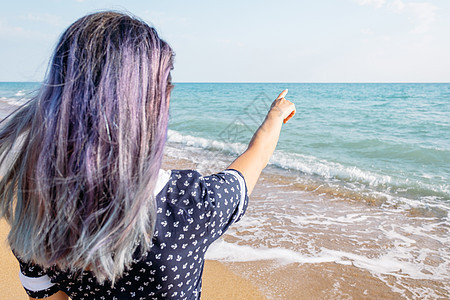 女人指向海面 复制空间图片