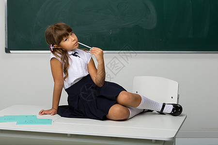 坐在教室桌上的可爱女孩学生辫子学习裙子班级马尾辫教育知识女性课堂图片