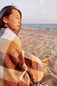 年轻女人坐在沙滩上旅行女士海岸海洋女孩海滩日落娱乐微笑女性图片
