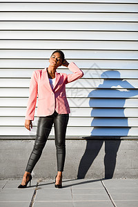 黑人妇女 时装模特 站在城墙上街道头发短发微笑人士套装女性粉色冒充成人图片