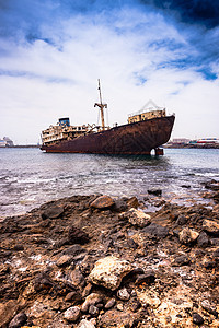 兰萨罗特海岸附近被破解的船废料损害衰变血管海洋海滩海景凹陷蓝色废墟图片