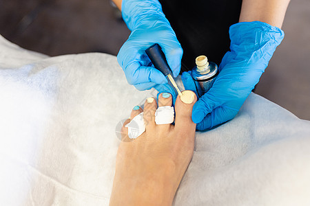 美容师在美容中心给客户涂了指甲油画治疗工具温泉保养商业美甲手套绘画指甲油美甲师图片