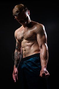 黑色背景的男人在健身健美二头肌运动中保持哑铃 男人强大 人有吸引力的皮肤力量 一个适合从下往上看好压力美丽的肌肉毛茸茸的胸部魅力图片