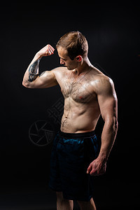 黑色背景的男人让哑铃在健身运动员训练中保持强劲 男性年轻金属 人体健康图片