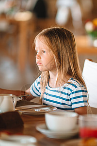 可爱的小女孩在户外咖啡厅吃早餐餐厅果汁水果婴儿女孩瓶子假期食物稀饭桌子图片