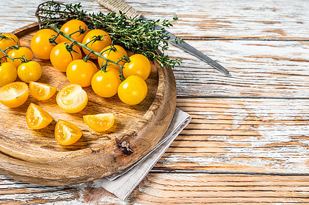 将黄樱桃西红柿切在配有草药的木托盘上 白木背景 顶视图蔬菜白色饮食团体黄色水果收成农业食物橙子图片