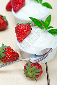 希腊有机酸奶和草莓水果奶制品叶子小吃饮食奶油牛奶勺子浆果宏观图片