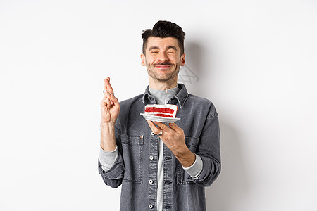 满怀希望的生日男人 用手指许愿 在派对上举行生日蛋糕 站在白色背景下站立成人发型广告办公室纪念日促销工作室男性成功胡子图片