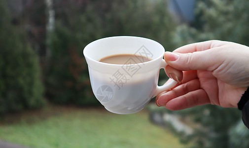 女孩手拿着一杯白咖啡 绿色自然背景模糊 在山脉背景下的女性手中的杯子咖啡店女士饮料气氛天空闲暇酒店成人幸福假期图片