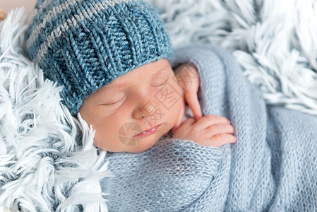 新生儿睡在蓝毯子里的盒子里男生新生帽子玩具午睡女孩姿势睡眠兔子野兔图片