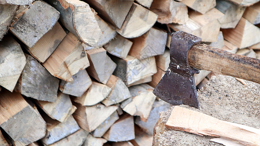 劈柴供冬天取暖 斧头用刀片刺入树桩 带有木柄的切肉刀 在农场收割 成堆堆放的干柴用于加热房屋壁炉战斧日志森林木工人木头乐器记录工图片