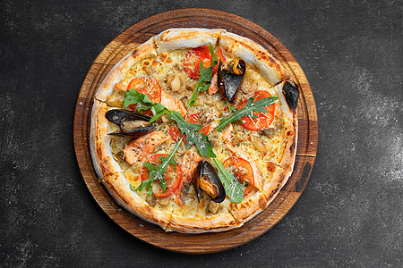 木板上的鲑鱼扇贝披萨和海鲜壳送货香料餐厅食物午餐厨房草药面包小吃蔬菜图片