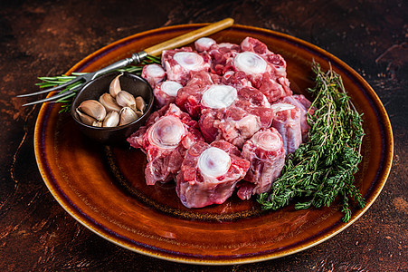 含草药的生锈板上的肉类 深色背景 顶部视图羊肉桌子尾巴奶牛食物山羊屠夫黑色牛尾饭馆图片