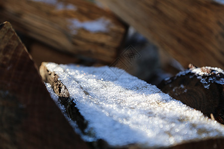 冬天堆放的柴火 木桩与积雪堆放的木柴 雪下砍伐的木柴 成堆的积雪的木柴在寒冷的冬日图片