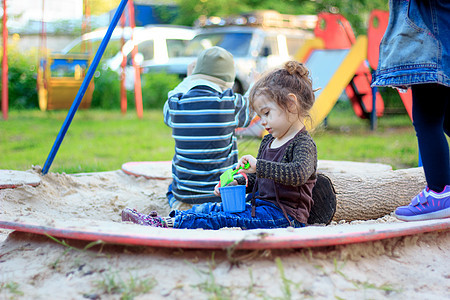 小女孩在操场上玩沙子和水桶的小姑娘乐趣儿童童年男生玩具婴儿女孩海滩操场公园图片