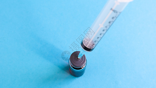 注射器从红色液体瓶中伸出 隔离在蓝色背景上 医学 注射剂 疫苗和一次性注射器 药物概念 无菌瓶 注射用玻璃安瓿医疗疾病药品科学塑图片