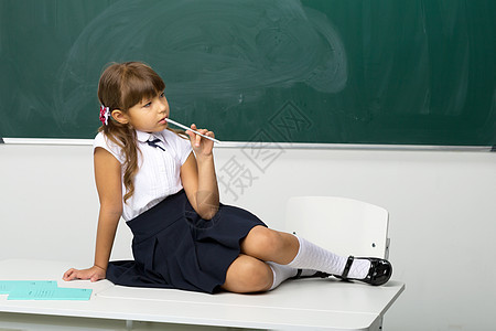 坐在教室桌上的可爱女孩班级木板马尾辫教育女性孩子辫子裙子黑板知识图片