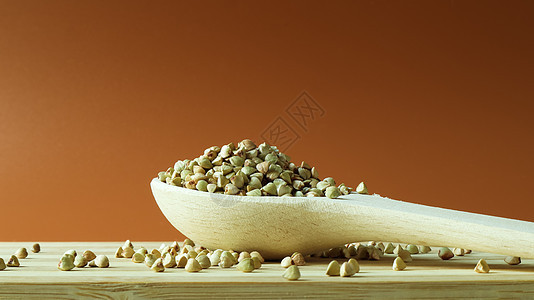 棕色背景上木勺中的绿色荞麦 好食物 健康的碎粒 有机生非油炸素食 健康均衡饮食的概念 减肥食品 复制空间勺子核心桌子烹饪粮食维生图片