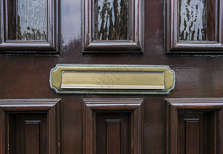 带有传统金色信箱的深褐木前门黑棕木金属建筑邮资房子邮箱住宅邮政反射窗户玻璃图片