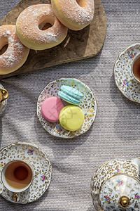 餐桌上的茶杯和马卡松 古董茶壶和下午茶顶风景甜甜甜圈图片