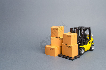 有纸板箱的黄色铲车 货物在仓库中的存储 交付和运输服务 货运 送货 进出口 对外商品交换图片