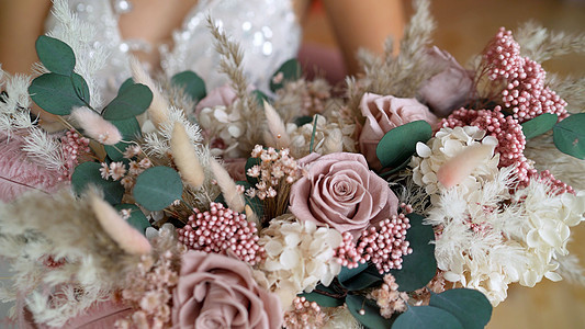 新娘手里拿着一束美丽的粉色和白色花朵的婚礼花束 美丽的婚礼花束在新娘的手中图片