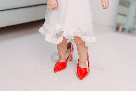 穿着红色高跟鞋的小女孩腿裙子妈妈乐趣母亲孩子婴儿模仿童年女孩女性图片