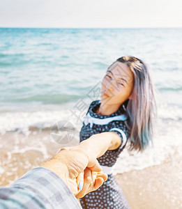 女人握着男人的手 把他引到海里海岸旅行友谊领导夫妻假期旅游闲暇女性女士图片