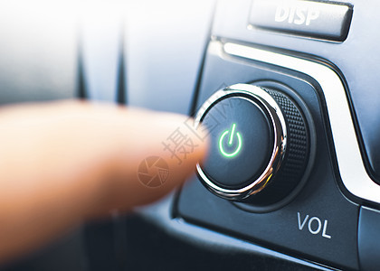 司机在汽车中按下音频播放器的电按钮图片
