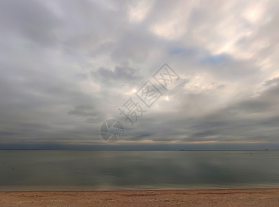 寒冷的秋季海滨背景 沙漠海滩 平静的大海 多云的天空和地平线上的海雾图片