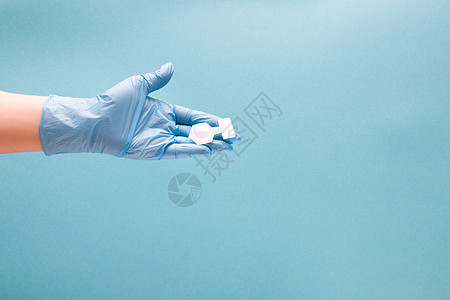 蓝色一次性医用手套中的女性手握有吸入药物的容器 蓝色背景复制空间 哮喘和支气管痉挛的治疗 肺单化症概念问题支气管炎症状女士病人过图片