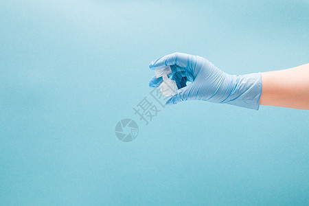 蓝色一次性医用手套中的女性手握有吸入药物的容器 蓝色背景复制空间 哮喘和支气管痉挛的治疗 肺单化症概念治愈支气管炎肺炎过敏剂量诊图片