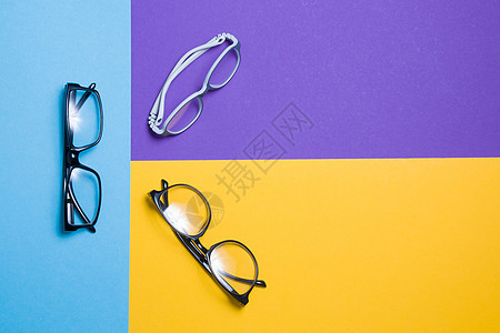 彩色背景上的几副眼镜 顶视图 买眼镜 眼镜店和眼镜框 儿童眼镜和成人眼镜阴影焦点眼睛眼科镜片框架塑料护理临床配饰图片